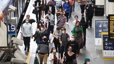 People, some wearing protective face masks, walk through Waterloo Station, amid the coronavirus disease, in London, Britain, July 4, 2021. (Reuters/Henry Nicholls)