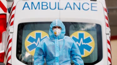 A medical worker wearing protective gear stands next to an ambulance outside a hospital for patients infected with COVID-19 in Kiev, Ukraine, November 24, 2020. (Reuters/Gleb Garanich)
