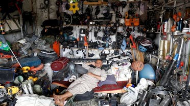 An Afghan man rests in his shop as he sells US second-hand materials outside Bagram US air base, Afghanistan July 5, 2021. (Reuters)