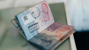 A passport with country entry stamps is pictured. (Unsplash, Henry Thong)