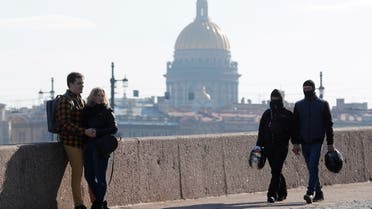 People rest on the Spit of Vasilievsky Island with the St. Isaac's Cathedral in the background in central Saint Petersburg, Russia. (File Photo: Reuters)