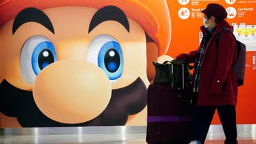A traveler walks past a propaganda featuring Nintendo character at Narita airport in Narita, near Tokyo. (AP)