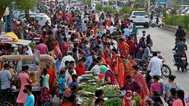 People shop at a crowded roadside vegetable market after authorities eased coronavirus restrictions, following a drop in COVID-19 cases in Ahmedabad, India, June 15, 2021. (Reuters)