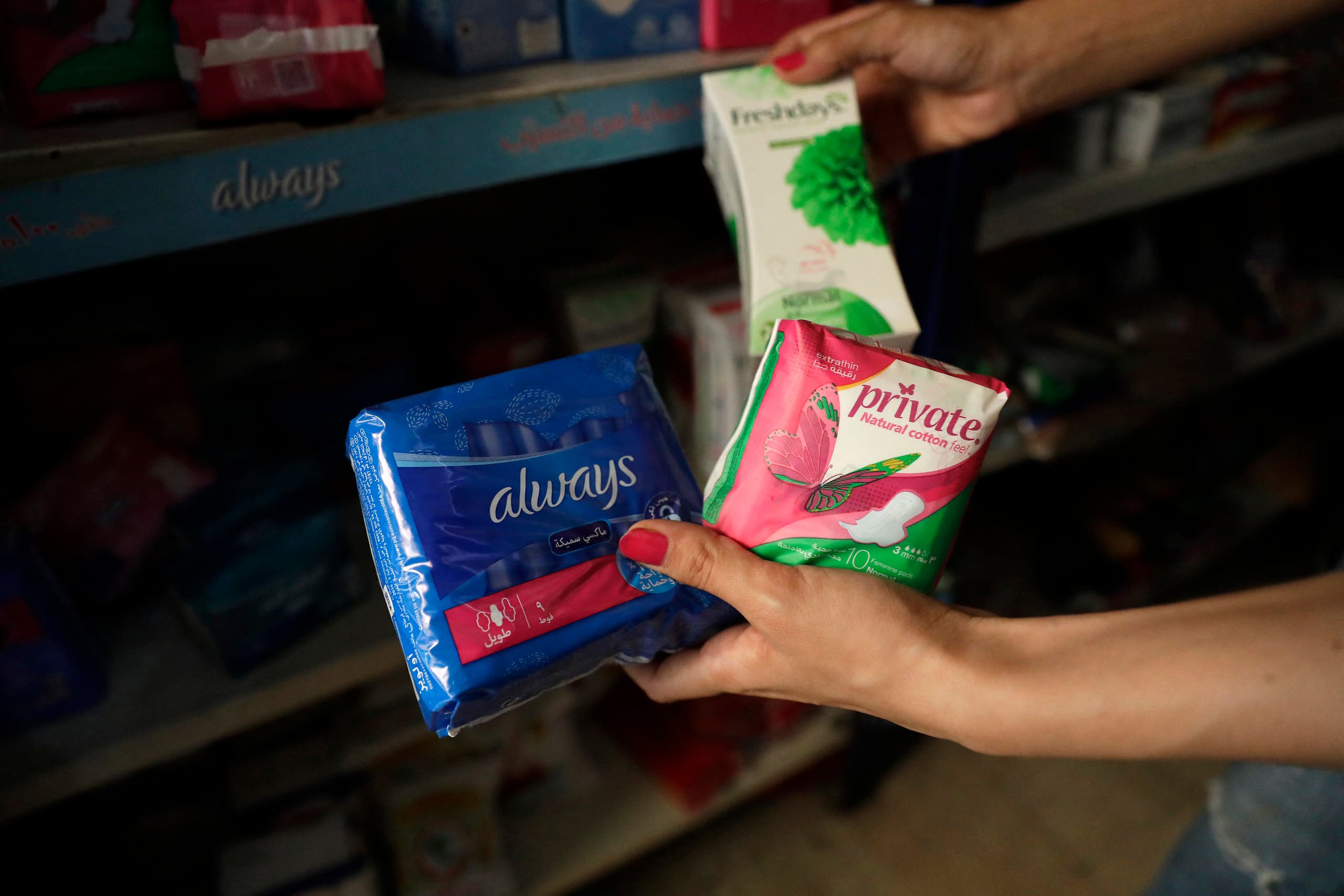 A Lebanese woman inspects prices of female sanitary pads at a shop in the capital Beirut on June 23, 2021. (AFP)