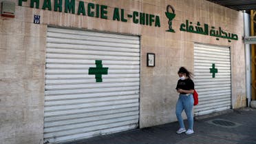 A woman passes by a closed pharmacy in Beirut, Lebanon, Friday, June 11, 2021. (AP)