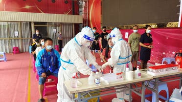 People line up for nucleic acid testing at a residential compound following new cases of the coronavirus disease (COVID-19) in Ruili, a border city with Myanmar, in Yunnan province, China July 5, 2021. (Reuters)