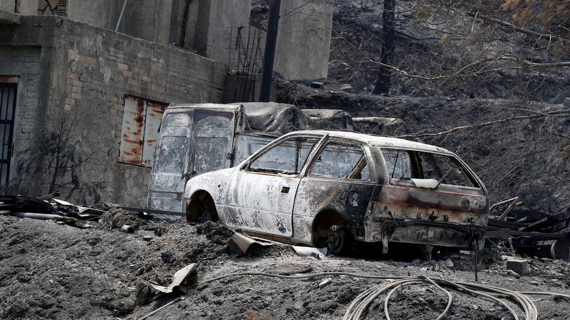 Burned house and cars are seen following a wildfire near the village of Melini, in the Larnaca mountain region, Cyprus July 4, 2021. REUTERS/George Christophorou NO RESALES. NO ARCHIVES.