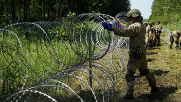 Lithuanian army soldiers install razor wire on border with Belarus in Druskininkai, Lithuania, on July 9, 2021. (Reuters)