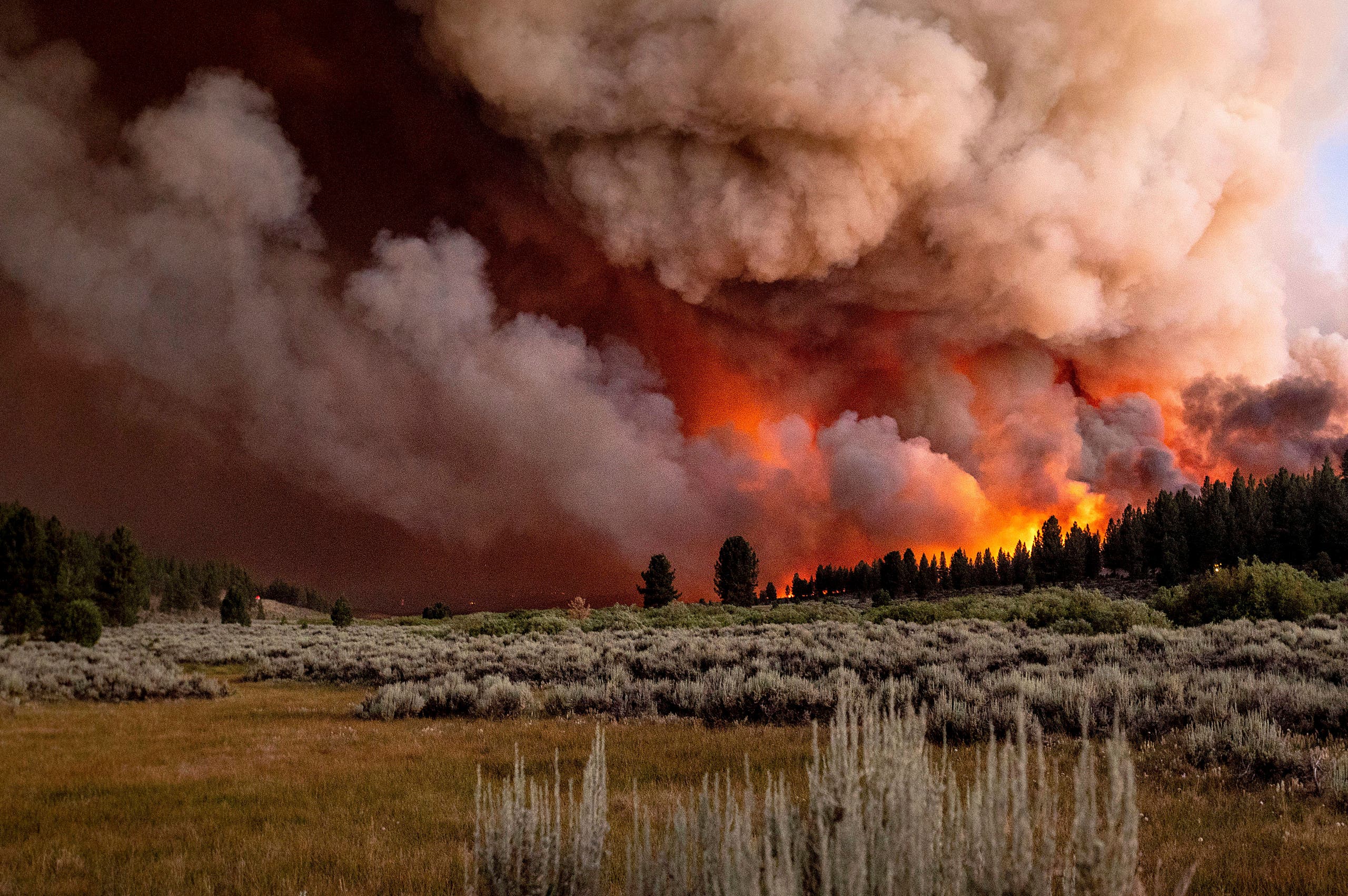 Plumes of smoke and fire rise above Frenchman Lake as the Sugar Fire, part of the Beckwourth Complex Fire, burns in Plumas National Forest, California, on Thursday, July 8, 2021. (AP)