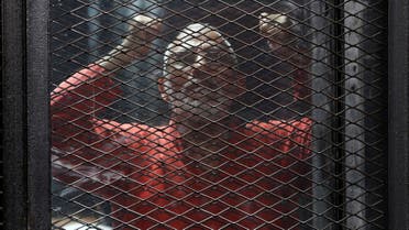 Muslim Brotherhood's leader Mohamed Badie shouts solgans against the Interior Ministery behind bars during the trial of 738 brotherhood members for their armed sit-in at Rabaa square, at a court on the outskirts of Cairo, Egypt May 31, 2016. (Reuters)