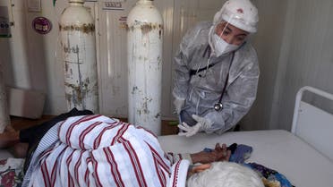A Tunisian nurse clad in PPE (personal protective equipment) tends to a Covid-19 coronavirus disease patient in an intensive care unit (ICU) at a hospital in the northwestern town of Beja, on June 22, 2021, as Tunisia's health authorities cope with a spike in Covid-19 cases in the area.