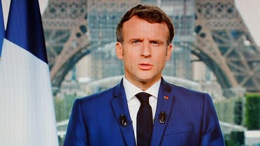 French President Emmanuel Macron is seen on a TV screen as he speaks during a televised address to the nation from the temporary Grand Palais in Paris on July 12, 2021. (Ludovic Marin/AFP)