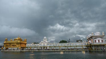 Sikh devotees wait for their turn to pay respect at the Golden Temple during a rainfall in Amritsar on July 11, 2021.