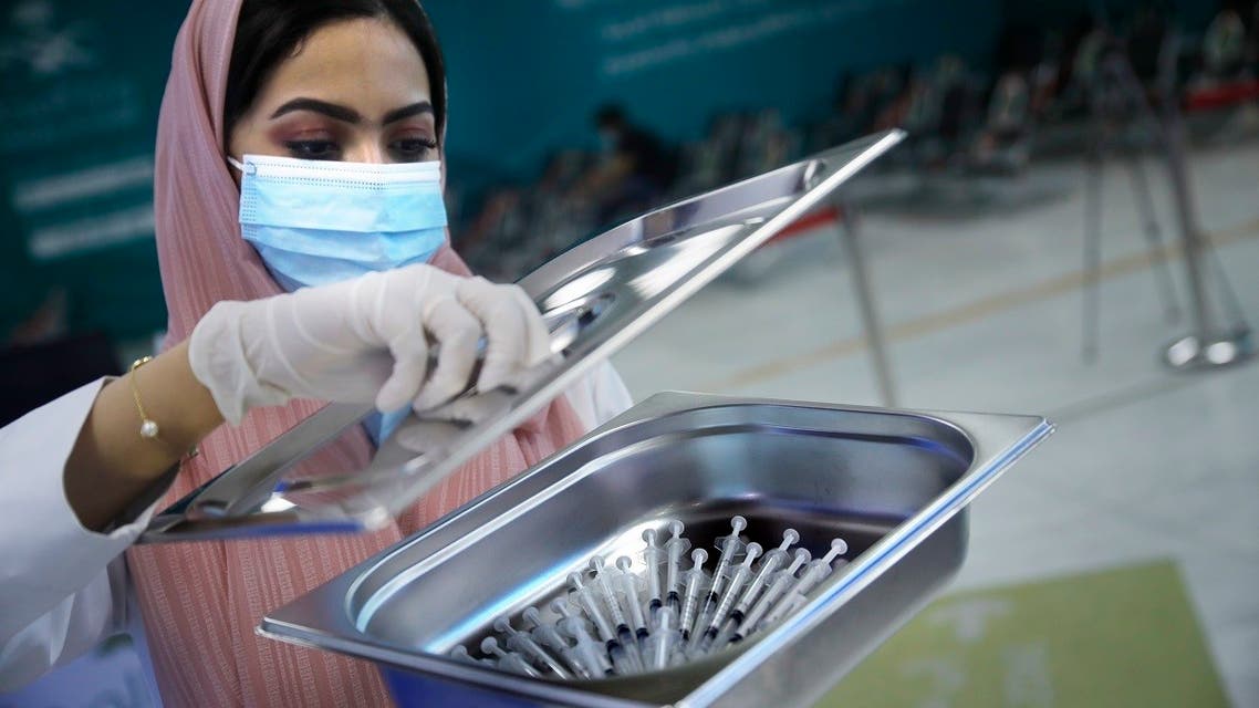 A Saudi health worker carries a tray of Pfizer coronavirus vaccines, at a vaccination center in the old Jeddah airport, Saudi Arabia, on May 18, 2021. (AP)
