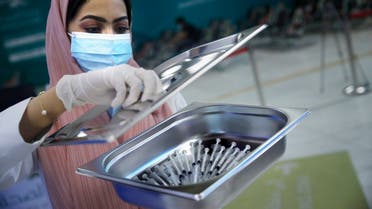 A Saudi health worker carries a tray of Pfizer coronavirus vaccines, at a vaccination center in the old Jiddah airport, Saudi Arabia, Tuesday, May 18, 2021. (AP)