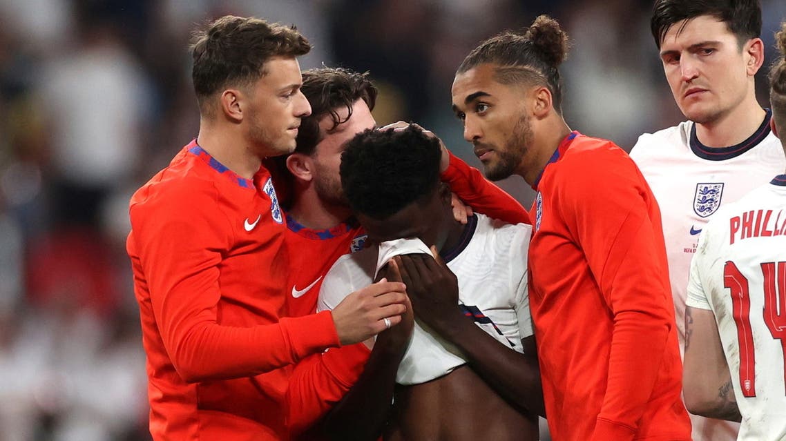  England's Bukayo Saka looks dejected after losing the penalty shootout as teammates console him. (Reuters)