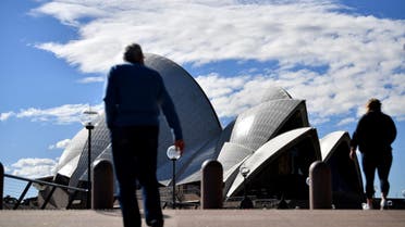 This picture taken on June 26, 2021 shows people walking in front of the Opera House, usually packed with visitors, as a lockdown in Australia's largest city Sydney was tightened on July 9, 2021. (File photo: AFP)