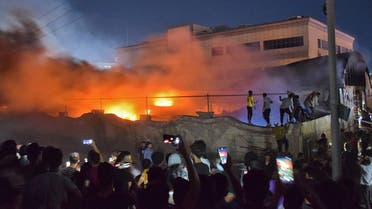 People gather as a massive fire engulfs the coronavirus isolation ward of Al-Hussein hospital in the southern Iraqi city of Nasiriyah, late on July 12, 2021. (File photo: AFP)