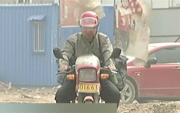 Guo Gangtang, now 51, started searching for his missing son on a motorcycle carrying a flag with his son’s photo and details. (AFP)