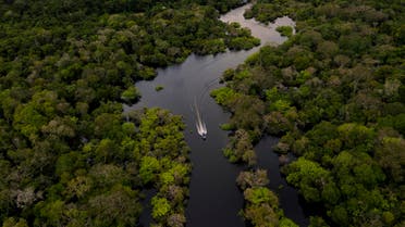 Aerial view showing a boat speeding on the Jurura river in the municipality of Carauari, in the heart of the Brazilian Amazon Forest, on March 15, 2020. Many young people in the heart of the Amazon rainforest choose their community over the city.