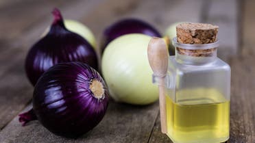 Onion juice and vegetables on a wooden table. Home-made syrup for the treatment of influenza. Dark background stock photo