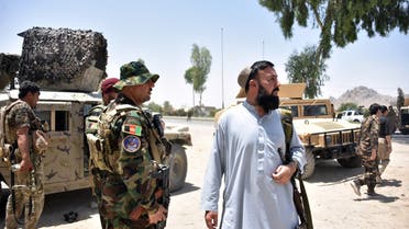 Afghan security personnel stand guard along the road amid ongoing fight between Afghan security forces and Taliban fighters in Kandahar on July 9, 2021.