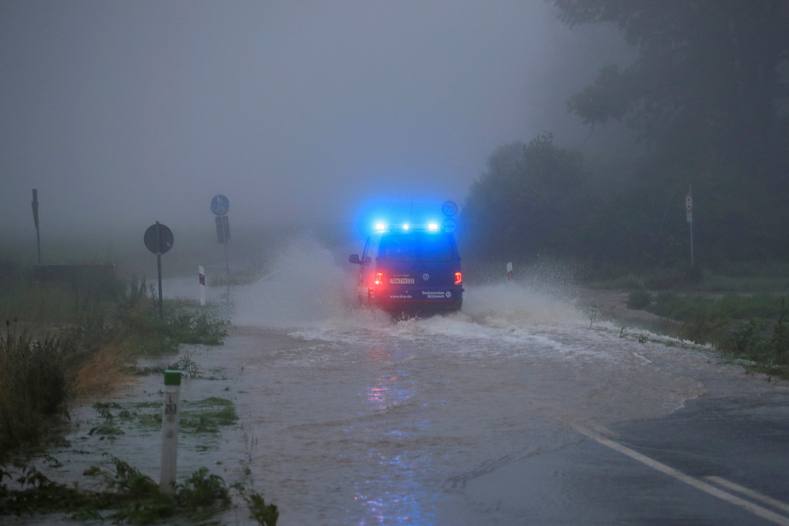 A vehicle travels on a flood affected road after the Erft river swelled following heavy rainfalls in Erftstadt, near Cologne, Germany, July 15, 2021. (Reuters)