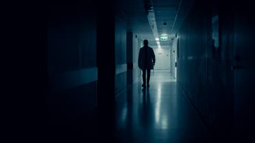 Medical Doctor Silhouette Walks in Dark Part of the Hospital Corridor. stock photo