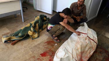 Syrians mourn over the body of one of the victims of a reported regime artillery shelling, in the village of Iblin in the Jabal al-Zawiya region of Syria's rebel-held northwestern Idlib province, on July 3, 2021. Six children were among eight civilians killed by regime artillery fire in Syria's last major rebel stronghold of Idlib in the country's northwest, a war monitor said.