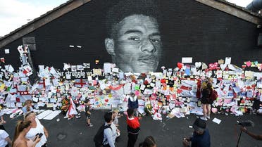 People look at messages of support on the Marcus Rashford mural in Withington, Manchester, Britain, on July 13, 2021, after it was defaced following the Euro 2020 Final between Italy and England. (Reuters)