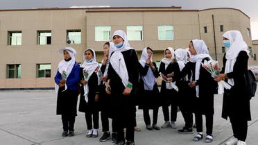 Schoolgirls hold flowers as they arrive to visit students who were injured in a car bomb blast outside a school on Saturday, at a hospital in Kabul, Afghanistan May 10, 2021.REUTERS/Stringer