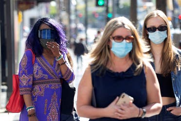 People wearing face protective masks walk on Hollywood Blvd during the outbreak of the coronavirus disease (COVID-19), in Los Angeles. (Reuters)