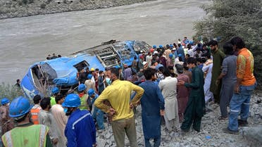 Rescue workers and onlookers gather around a wreck after a bus plunged into a ravine following a bomb explosion, which killed 12 people including 9 Chinese workers, in Kohistan district of Khyber Pakhtunkhwa province on July 14, 2021. (AFP)
