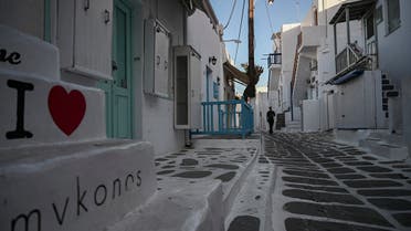 A man walks in the empty alleys of the Greek Cycladic island of Mykonos, on May 13, 2020. (AFP)