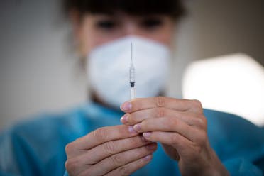 In this file photo taken on April 9, 2021, a nurse prepares a dose of the Pfizer/BioNTech Covid-19 vaccine at a vaccination centre set up at the exhibition hall in Nantes, western France. There is no need for the moment to offer a third dose of vaccine against Covid-19 to the entire population, apart from the most vulnerable and the oldest, for lack of available data, said the French High Authority for Health (HAS) on July 16, 2021. (AFP)