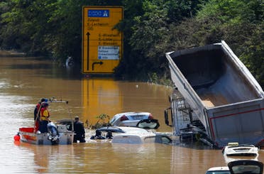 A police officer and a member of the Bundeswehr forces look at partially submerged cars on a flooded road following heavy rainfalls in Erftstadt-Blessem, Germany, July 17, 2021. (File photo: Reuters)