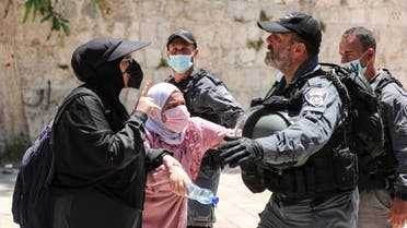 Palestinian women argue with an Israeli security force member after brief clashes erupted between Israeli police and Palestinians at al-Aqsa Mosque over visits by Jews on the Tisha B'Av fast day to the compound known to Muslims as Noble Sanctuary and to Jews as Temple Mount, in Jerusalem's Old City, July 18, 2021. (Reuters)