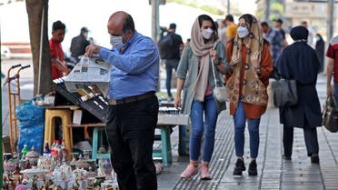 Iranians wear face masks as a measure against the COVID-19 coronavirus, in a street in the capital Tehran, on July 7, 2021. (Atta Kenare/AFP)