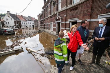 European Commissioner for Justice Didier Reynders speaks with Madeline Brasseur, 37, Paul Brasseur, 42, and their son Samuel, 12, at an area affected by floods, following heavy rainfalls, in Pepinster, Belgium, July 17, 2021. (Reuters)