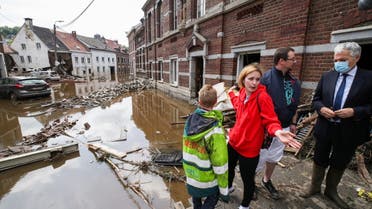 European Commissioner for Justice Didier Reynders speaks with Madeline Brasseur, 37, Paul Brasseur, 42, and their son Samuel, 12, at an area affected by floods, following heavy rainfalls, in Pepinster, Belgium, July 17, 2021. (Reuters)