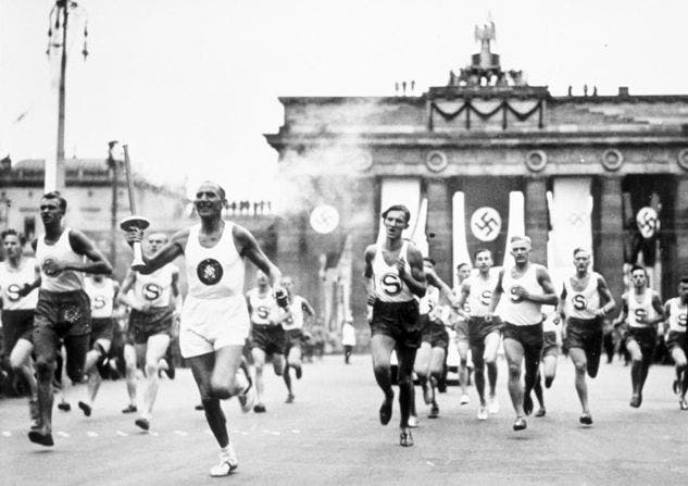 The Olympic torch as it descends in Berlin and passes by the Brandenburg Gate