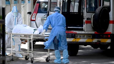 Hospital staff take out a body from an ambulance at a mortuary in New Delhi on May 24, 2021, as India passes more than 300,000 deaths from coronavirus pandemic.