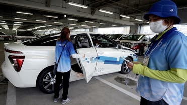 A staff member gets into a Toyota Mirai fuel cell electric vehicle (FCEV) during a demonstration of the transport operation support system for Tokyo 2020 Olympic Games personnel, in Tokyo, Japan, on July 1, 2021. (Reuters)