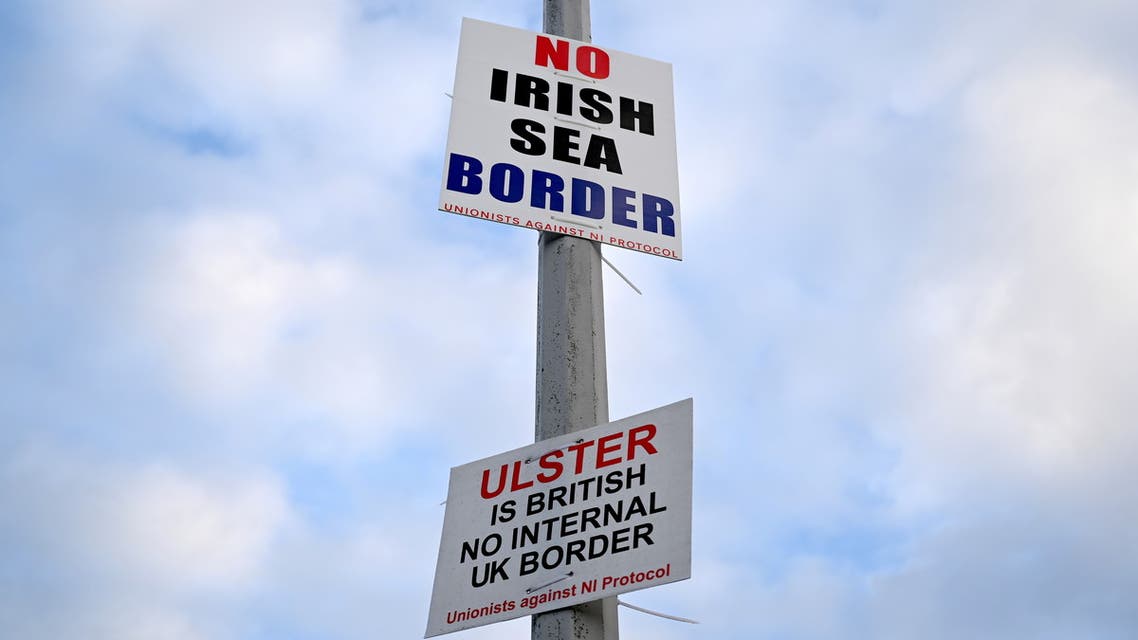 FILE PHOTO: Signs reading 'No Irish Sea border' and 'Ulster is British, no internal UK Border' are seen affixed to a lamp post at the Port of Larne, Northern Ireland, March 6, 2021. Picture taken March 6, 2021. REUTERS/Clodagh Kilcoyne/File Photo