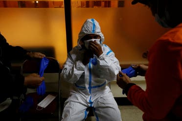 Komarudin, 48, a volunteer undertaker, prepares his personal protective equipment at the group's headquarters before collecting the body of a person who passed away due to complications related to COVID-19 whilst isolating at home in Bogor, West Java province, Indonesia, July 11, 2021. (Reuters)