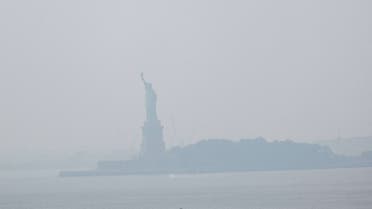 NEW YORK, NEW YORK - JULY 20: The Statue of Liberty sits behind a cloud of haze on July 20, 2021 in New York City. According to data from the National Oceanic and Atmospheric Administration, wildfire smoke from the west has arrived in the tri-state area creating decreased visibility and a yellowish haze in many areas. Spencer Platt/Getty Images/AFP
