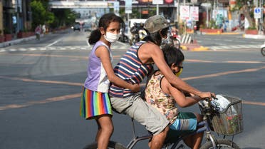 A father with his children aboard their bicycle crosses an almost empty road in Manila on March 20, 2020, after the government imposed an enhanced community quarantine against the rising numbers of COVID-19 coronavirus infections.. (File photo: AFP)
