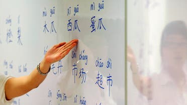 An instructor points out mandarin characters on a whiteboard at a night class for people learning mandarin as a second language in Singapore September 1, 2009. (Reuters)