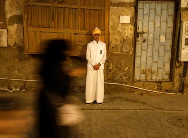 Woman walks past a boy wearing traditional costumes during the holy fasting month of Ramadan at Jeddah's historical area Al-Balad. (Reuters)