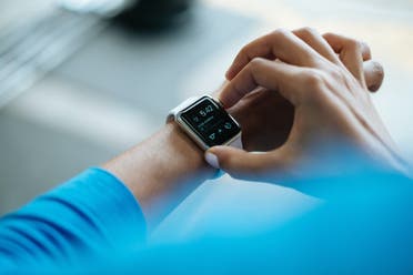 A man wearing a wearable watch to track fitness. (Unsplash, Luke Chesser)